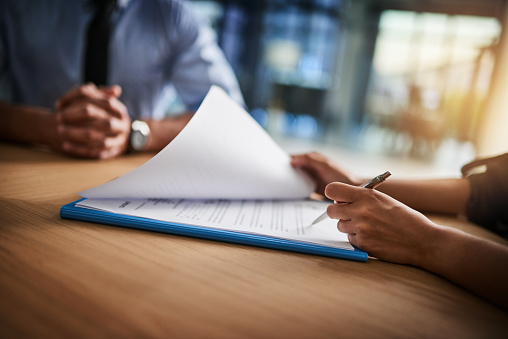 Cropped shot of a man and woman completing paperwork together at a desk airplane